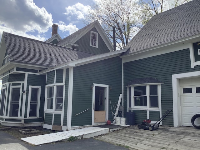 rear view of property with a garage