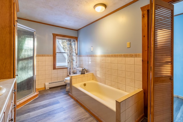 bathroom with wood-type flooring, a textured ceiling, tile walls, baseboard heating, and vanity