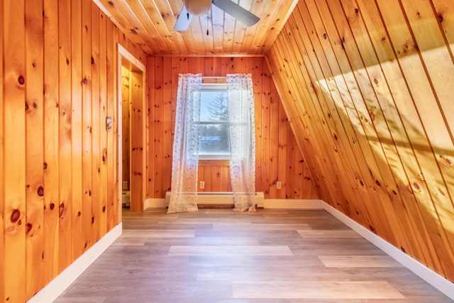 additional living space with wooden walls, baseboards, ceiling fan, wood ceiling, and light wood-style floors