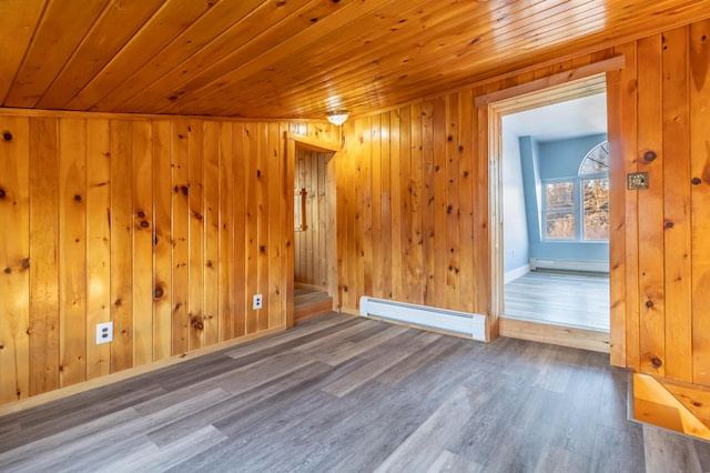 unfurnished room with a baseboard heating unit, wood ceiling, and wood finished floors