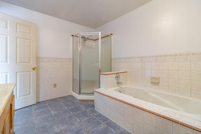 bathroom with tile walls, vanity, a shower with shower door, and tile patterned floors