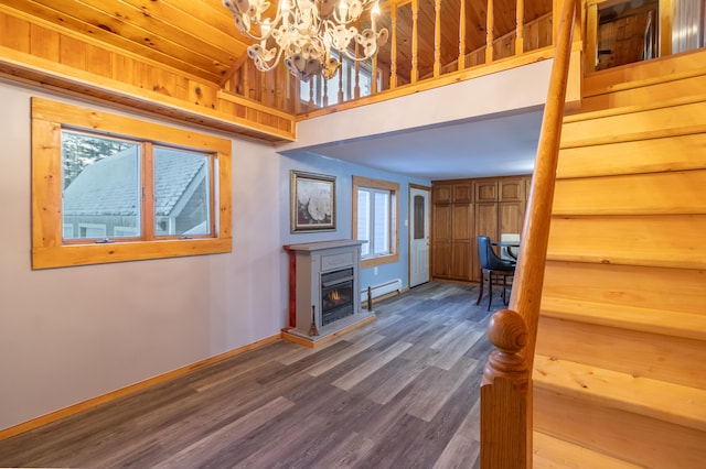 unfurnished living room with a notable chandelier, hardwood / wood-style flooring, and a baseboard radiator