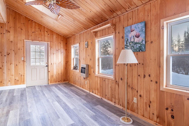 foyer entrance with heating unit, wood finished floors, baseboards, vaulted ceiling with skylight, and wooden ceiling