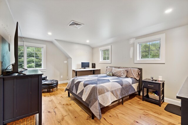 bedroom featuring vaulted ceiling and light wood-type flooring