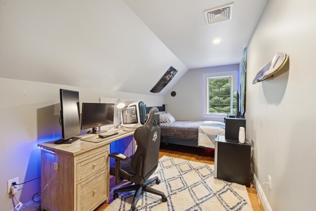 bedroom with lofted ceiling and light hardwood / wood-style floors