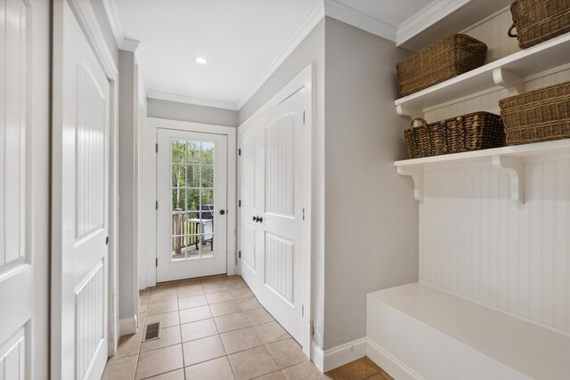 mudroom featuring ornamental molding and light tile patterned floors