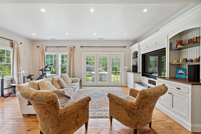 living room featuring french doors, light hardwood / wood-style flooring, and plenty of natural light