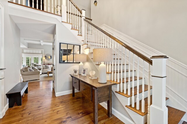 stairs featuring hardwood / wood-style flooring and a high ceiling