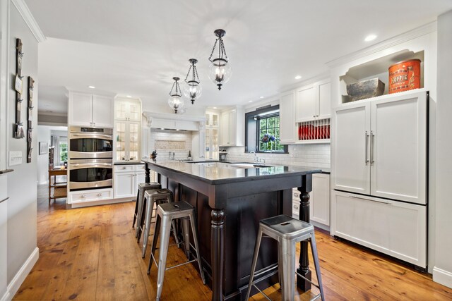 kitchen featuring light hardwood / wood-style floors, white cabinetry, and backsplash