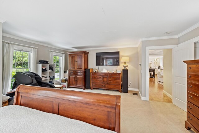 bedroom with crown molding and light carpet