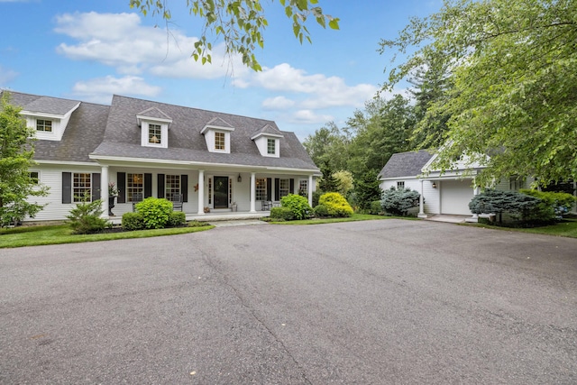 new england style home with a garage and covered porch