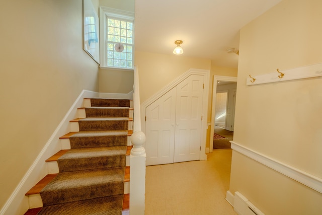 stairway with carpet and a baseboard radiator