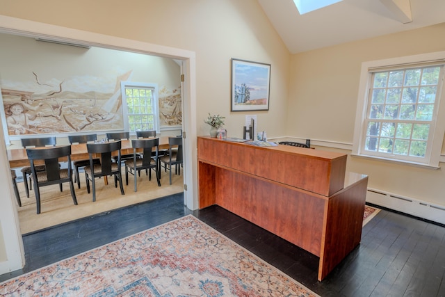 home office with dark hardwood / wood-style floors, a baseboard heating unit, and vaulted ceiling with skylight