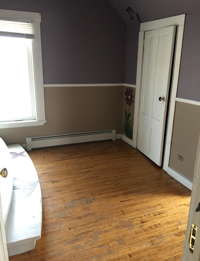 76 E Main St, Fort Kent, ME 04743 - unfurnished bedroom featuring baseboard heating, a closet, and light wood-style floors