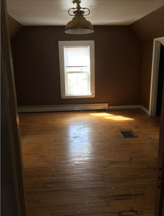76 E Main St, Fort Kent, ME 04743 - additional living space featuring baseboards, visible vents, lofted ceiling, hardwood / wood-style floors, and a baseboard heating unit