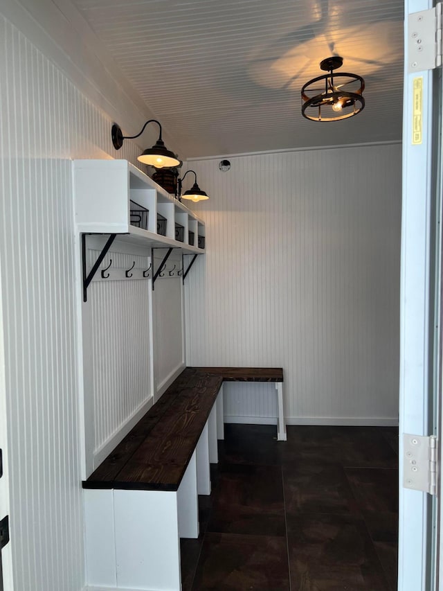 mudroom featuring a notable chandelier and wood walls