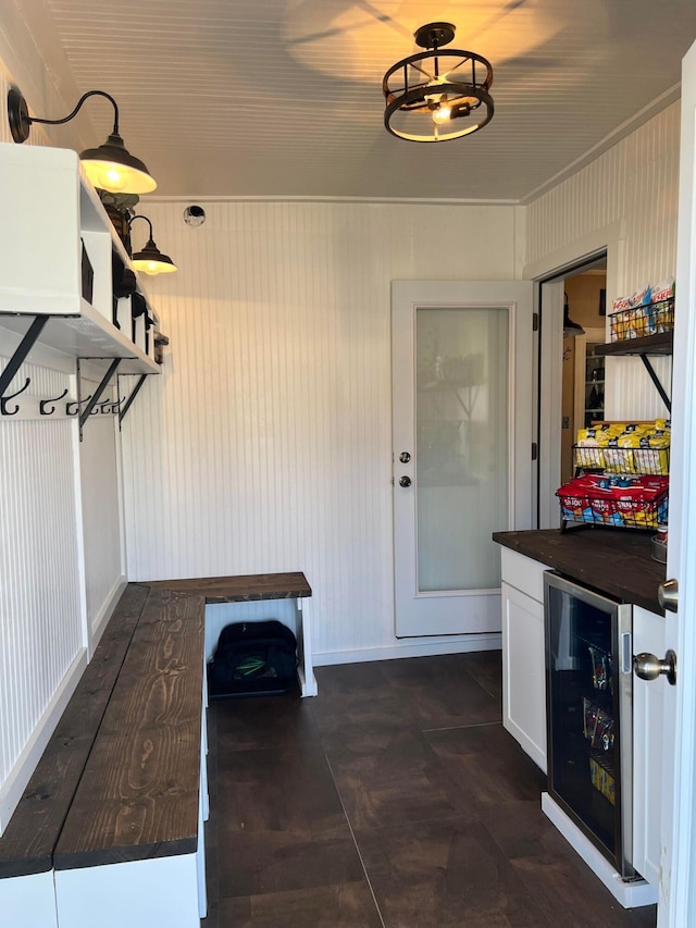 mudroom with wine cooler and wooden walls