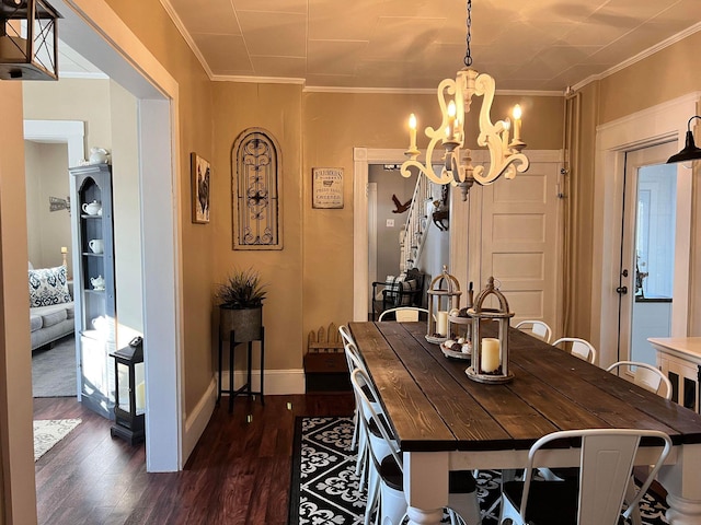 dining room with dark hardwood / wood-style floors, crown molding, and a chandelier