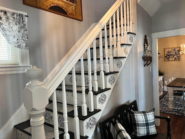 stairs featuring hardwood / wood-style floors and vaulted ceiling