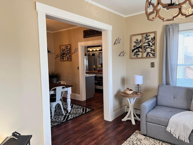 living area featuring dark wood-type flooring, crown molding, and a chandelier