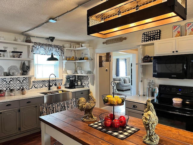 kitchen featuring gray cabinets, pendant lighting, black appliances, sink, and a textured ceiling