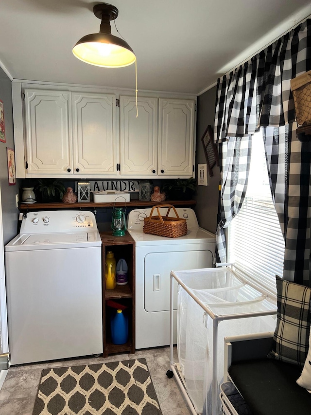 laundry area featuring washer and clothes dryer and cabinets