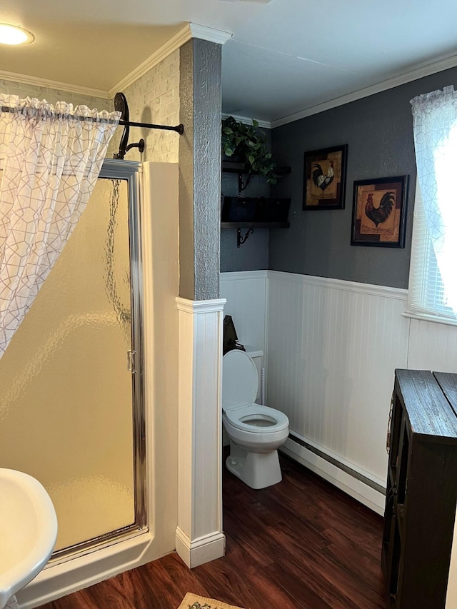 bathroom featuring hardwood / wood-style flooring, baseboard heating, a shower, and crown molding