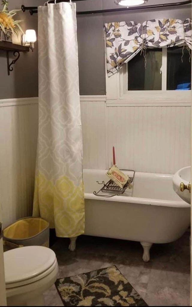 bathroom with toilet and shower / tub combo with curtain