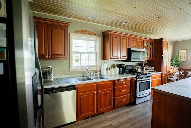 kitchen with crown molding, sink, wood-type flooring, stainless steel appliances, and wood ceiling