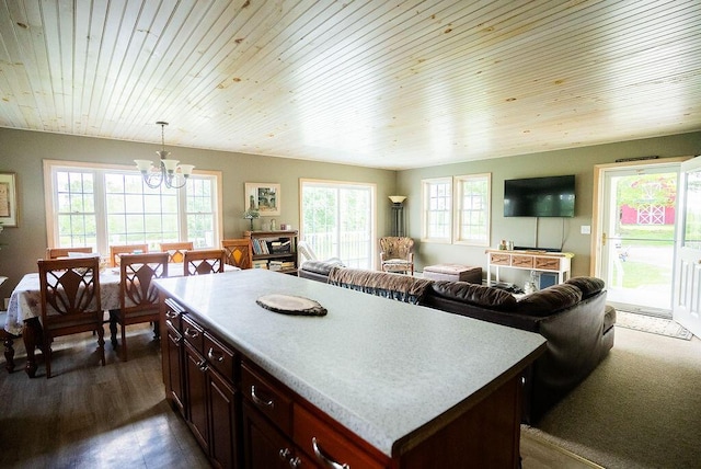 kitchen featuring dark hardwood / wood-style flooring, wood ceiling, pendant lighting, a notable chandelier, and a center island