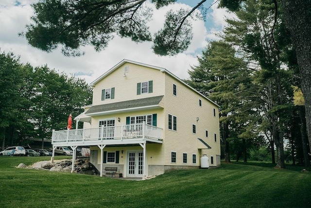 back of property featuring a wooden deck and a yard