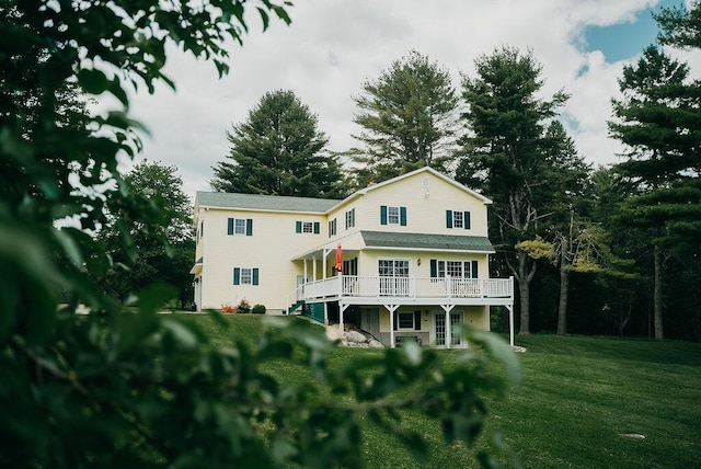 back of house with a lawn and a deck