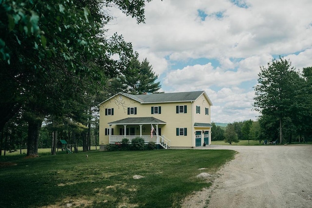 view of front facade with a porch, a garage, and a front lawn