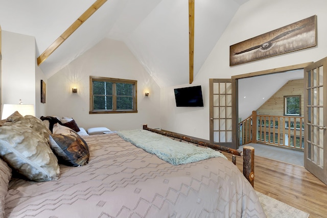 bedroom featuring light wood-type flooring, french doors, and vaulted ceiling