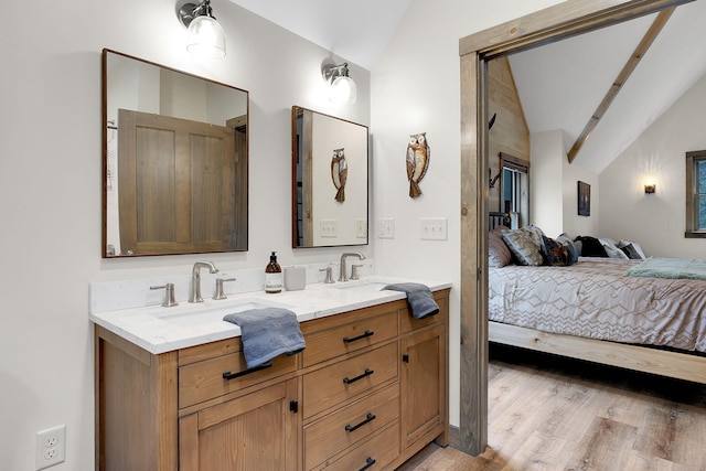 bathroom featuring vanity, vaulted ceiling, and wood-type flooring