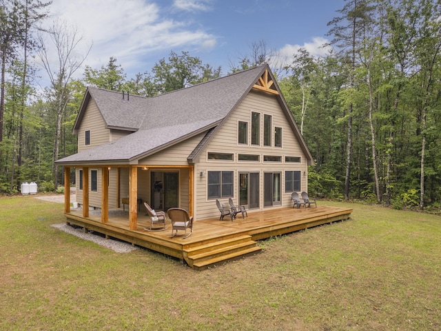 back of property featuring a wooden deck and a yard