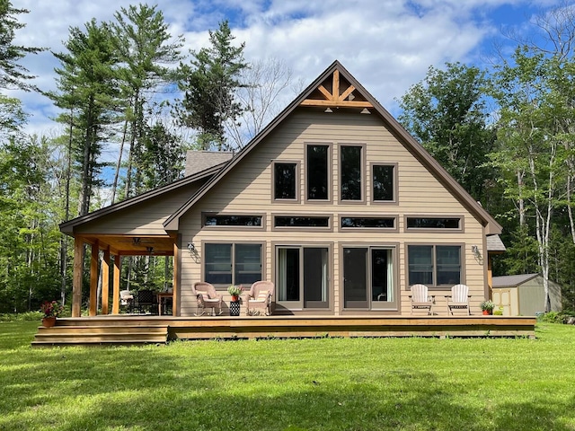 back of house with a storage shed, a wooden deck, and a lawn