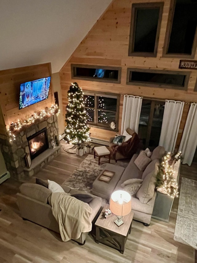 interior space featuring lofted ceiling, a fireplace, wood walls, and hardwood / wood-style flooring