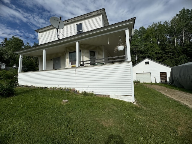 view of side of property with a garage, a porch, a yard, and an outdoor structure