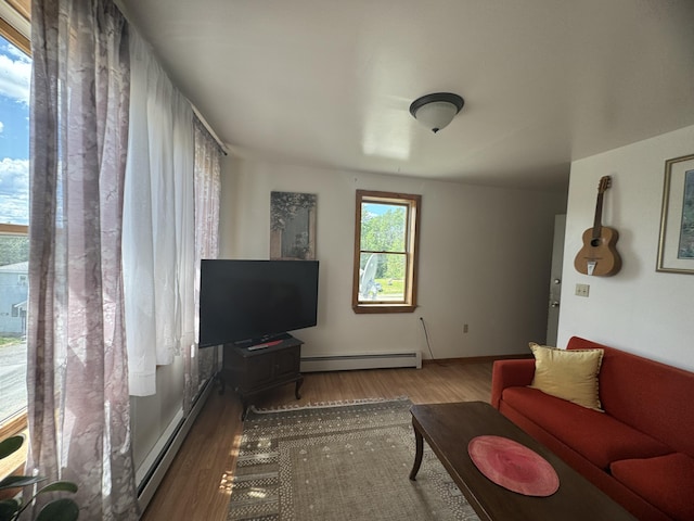 living room featuring a baseboard heating unit and hardwood / wood-style flooring