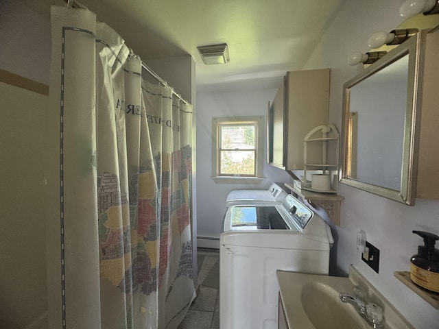 washroom with tile patterned floors, independent washer and dryer, a baseboard radiator, and sink