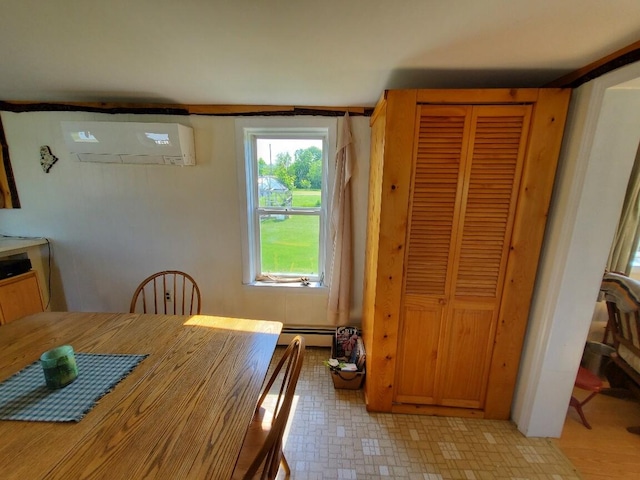 dining space with a wall unit AC and a baseboard heating unit