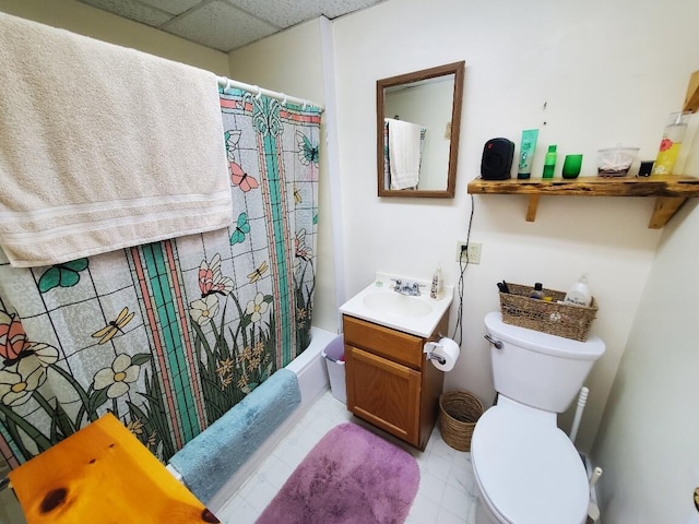 full bathroom with a paneled ceiling, shower / bath combo with shower curtain, vanity, and toilet