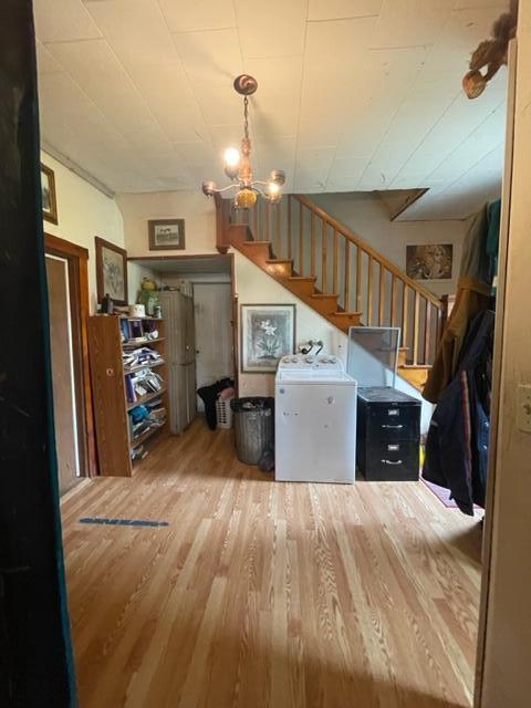 kitchen with an inviting chandelier, washer / dryer, and light hardwood / wood-style flooring