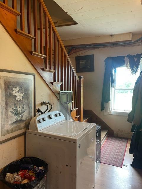 clothes washing area featuring wood-type flooring and washer / clothes dryer