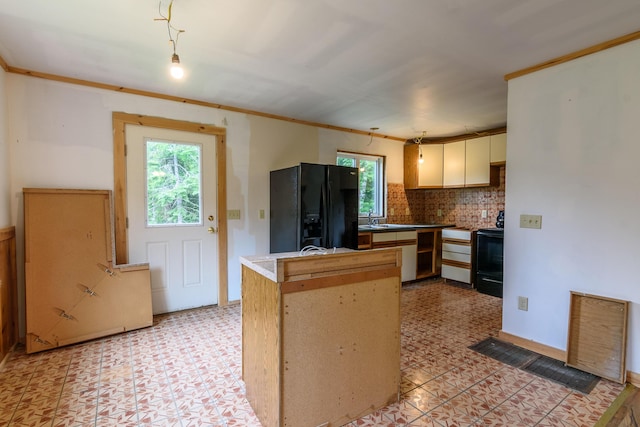 kitchen with kitchen peninsula, sink, a wealth of natural light, and black appliances