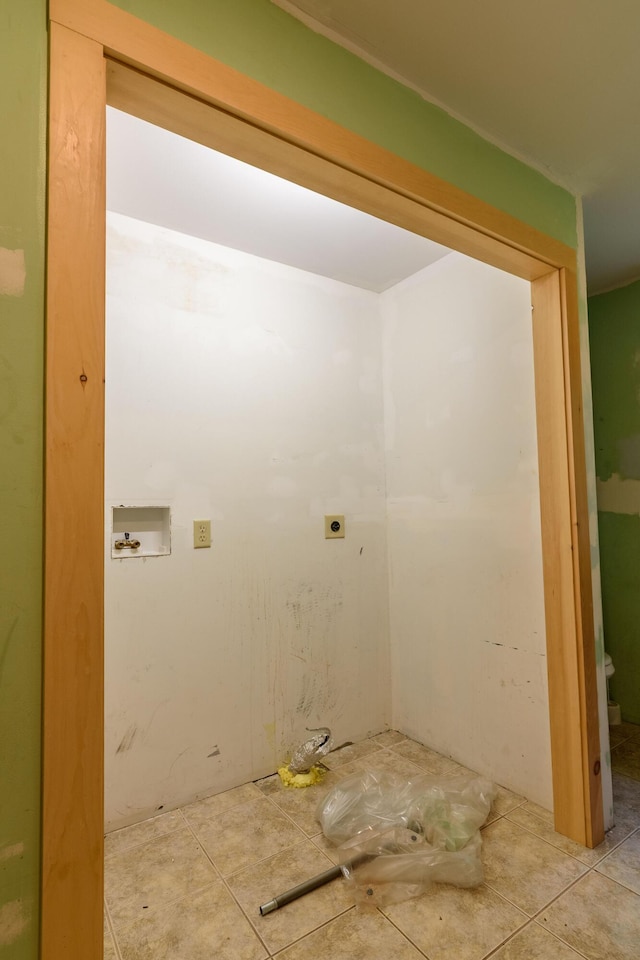 clothes washing area with hookup for an electric dryer, hookup for a washing machine, and light tile patterned floors