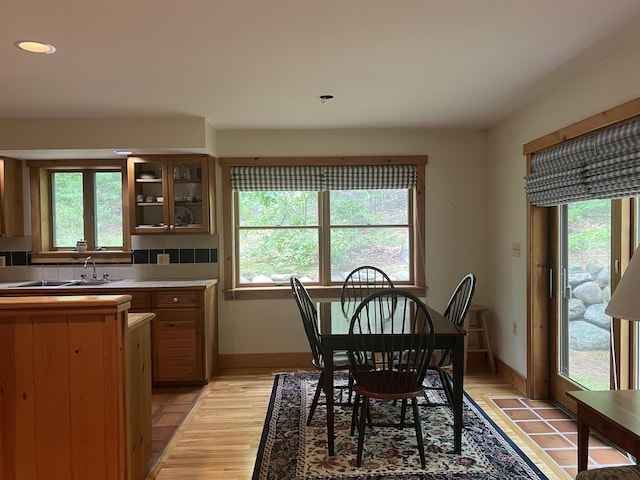 dining area featuring a healthy amount of sunlight, light wood-type flooring, and sink