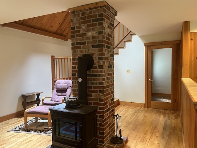 living area featuring a wood stove and light hardwood / wood-style flooring