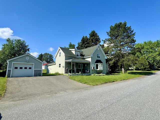 view of front of home featuring a front lawn, an outdoor structure, and a garage